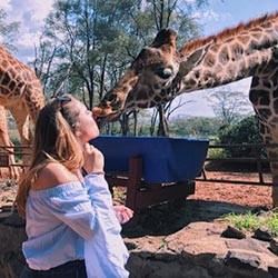Michaella Caruso receives a kiss from a giraffe.