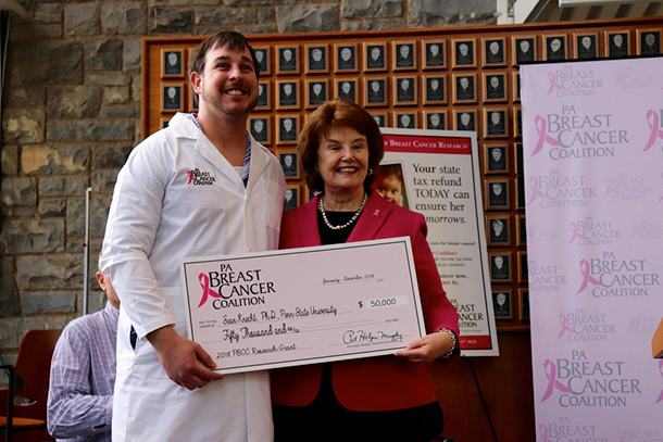 Sean Knecht receives a check from Pat Halpin-Murphy, the president and founder of the Pennsylvania Breast Cancer Coalition  