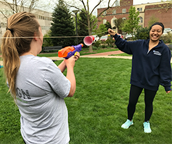 Members of the Britelab compete in a challenge where squirt guns were used to move a red plastic cup down a piece of string.
