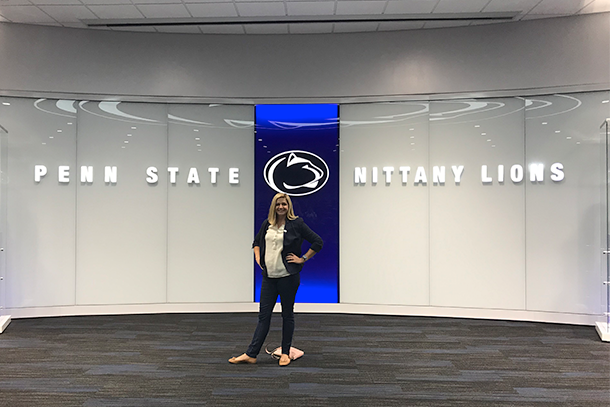 Woman standing in front of a Penn State Nittany Lions sign