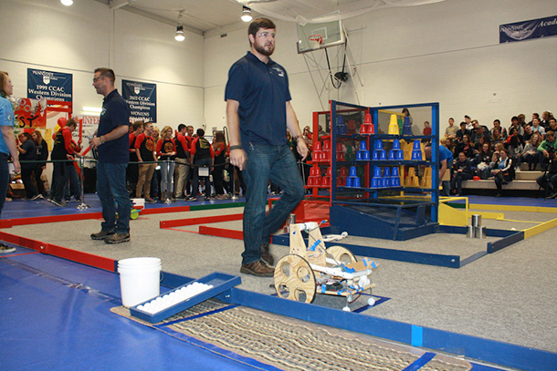 Two men walking around a robot obstacle course