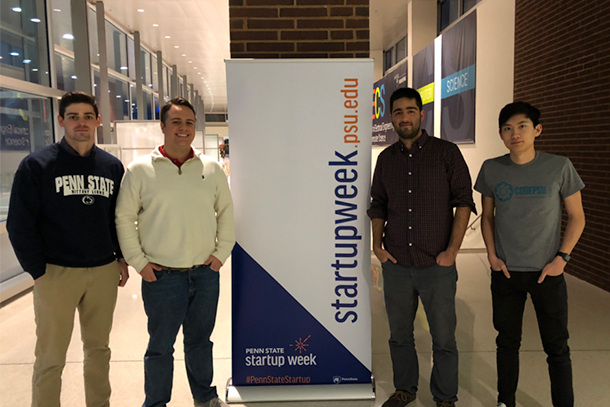 Four students standing near a sign for Penn State Startup Week
