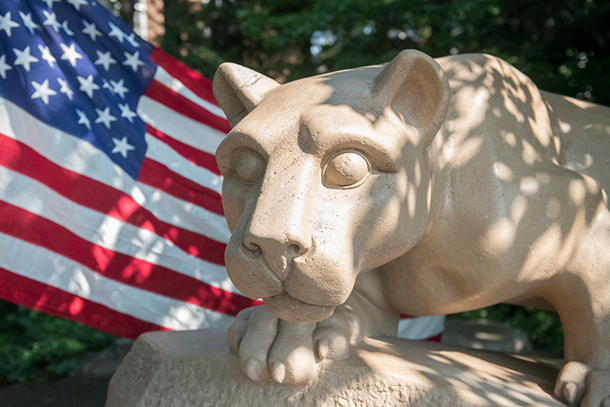 Nittany Lion Shrine with American flag in the background